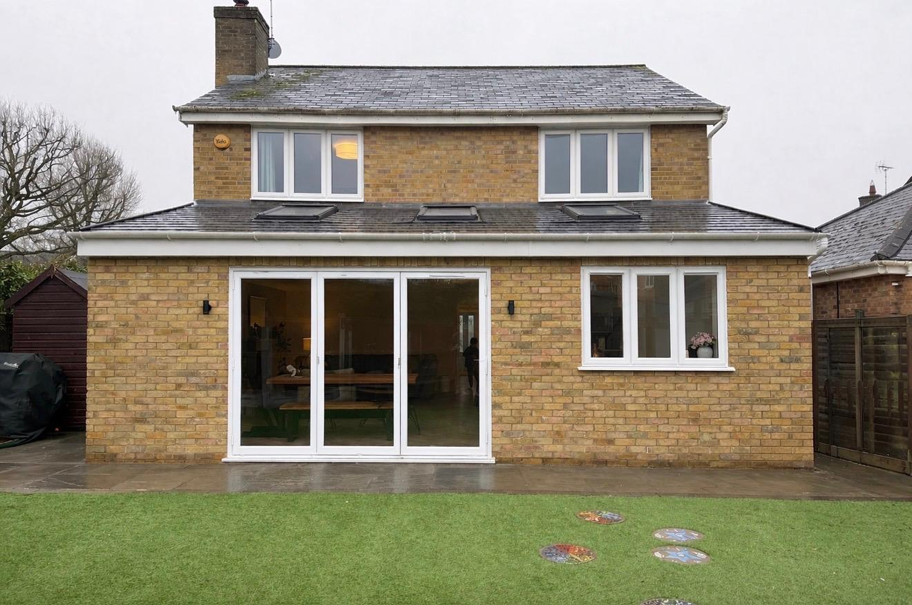 Full rear refurbishment with yellow stock brick, white bifold doors, dormers and porcelain patio